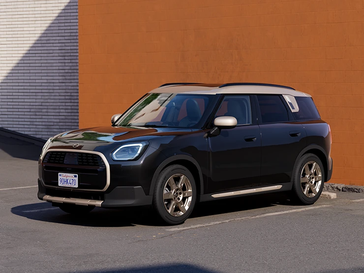 MINI Countryman в цвете Midnight Black II с белой крышей, припаркованный рядом с оранжевой стеной.