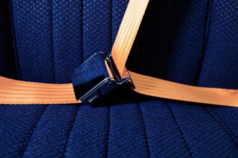 Безопасно и надежно: оранжевые ремни безопасности играют роль яркого акцента на фоне темно-синих подушек заднего сиденья.